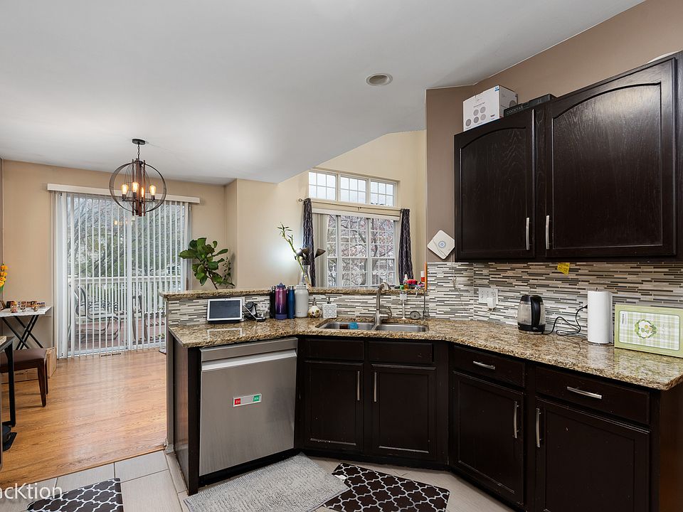 Kitchen with stainless steel appliances, dark cabinets, and granite countertops.