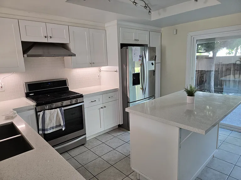 Upgraded kitchen with quartz countertops and stainless steel appliances.