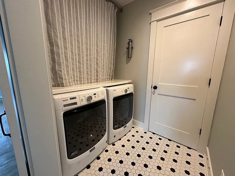 Laundry area with folding table and storage above. Can be concealed with barn door.