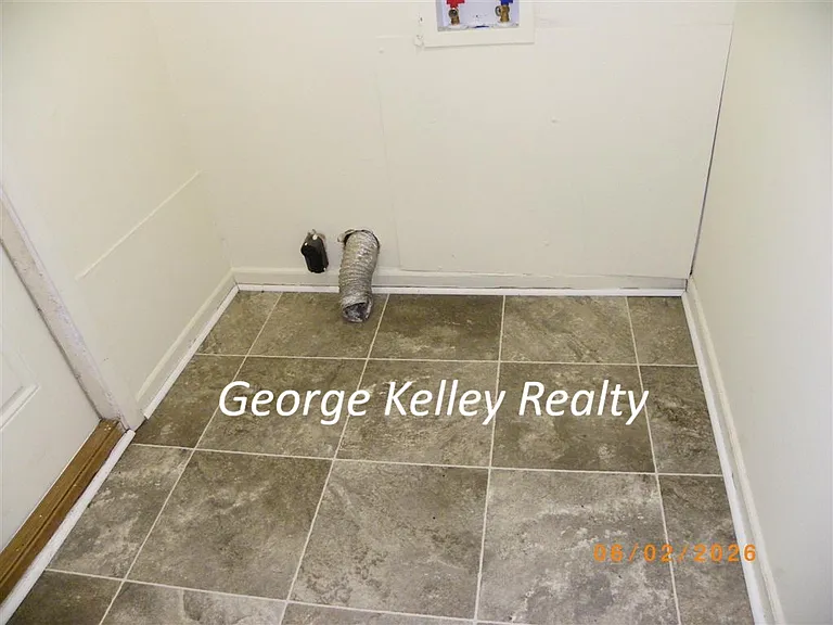 Laundry Room with new vinyl flooring and exterior door to driveway