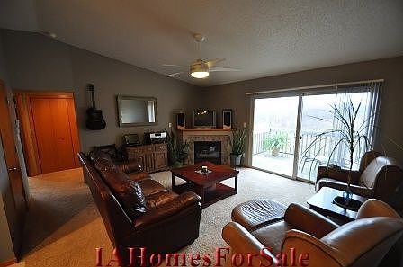 The spacious living room has a custom stone fireplace surround and views overlooking a wooded area.  The vaulted ceilings make this room extremely comfortable.