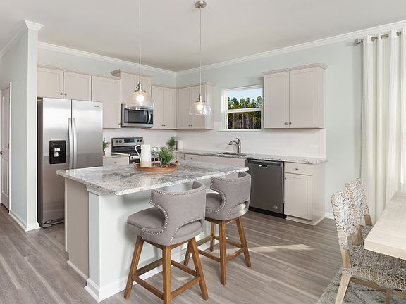 Open Kitchen with island, grey cabinets and Stainless Steel Appliances.