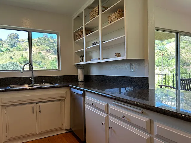 Solid granite countertops with open counter towards dining room.