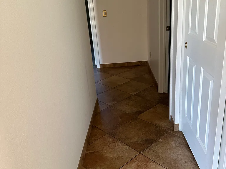 hallway with storage closet and full bathroom