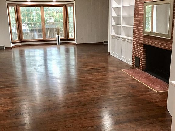 Large formal living room with built in bookcases and fireplace. Original wood floors.