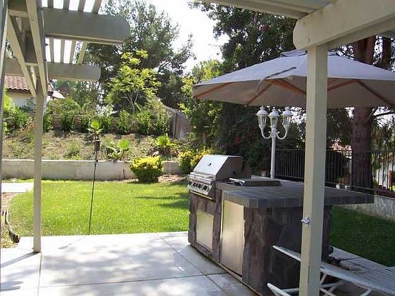Patio with BBQ and refrigerator.