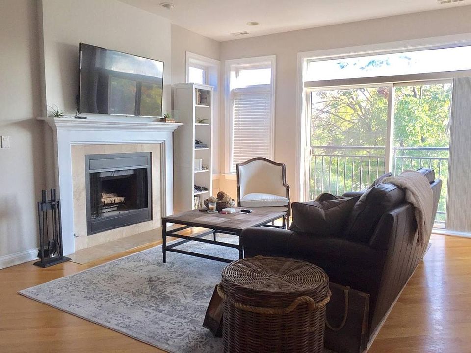 Living room with a fireplance, and a fake out balcolony that over looks the main tree-lined street.