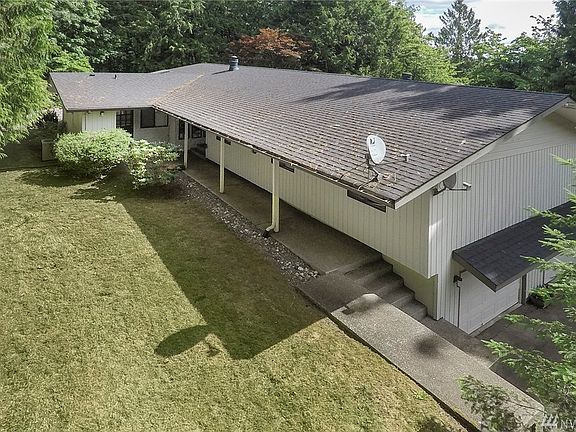 Side of home leading to front entrance with level yard space.
