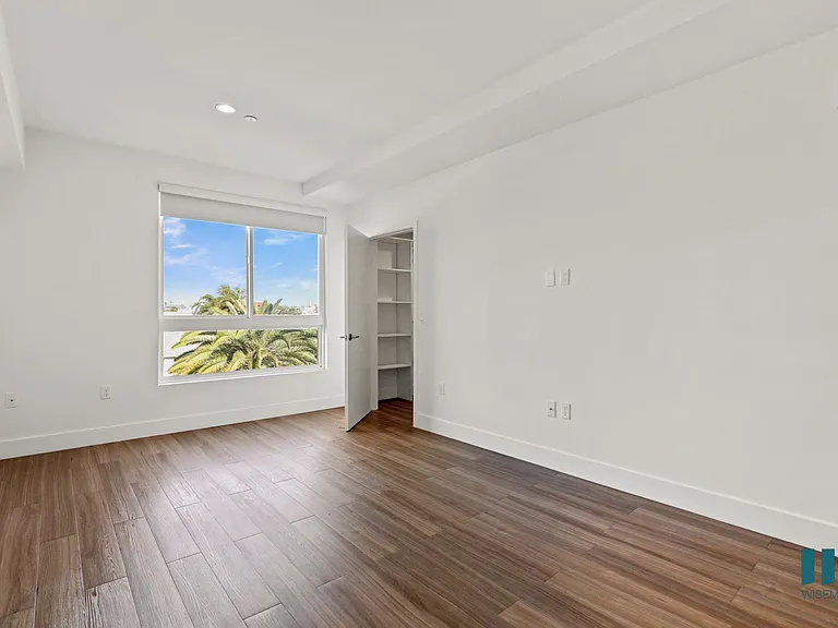 Spacious Bedroom with Vinyl Flooring, Recessed Lighting, and Walk-In Closet with Shelving