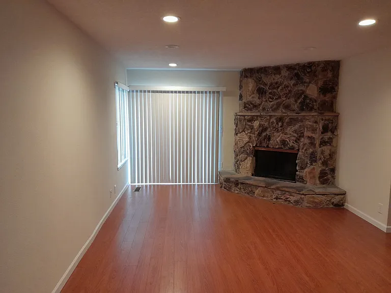 Family room with fireplace, recessed LED lights, and laminate wood floor