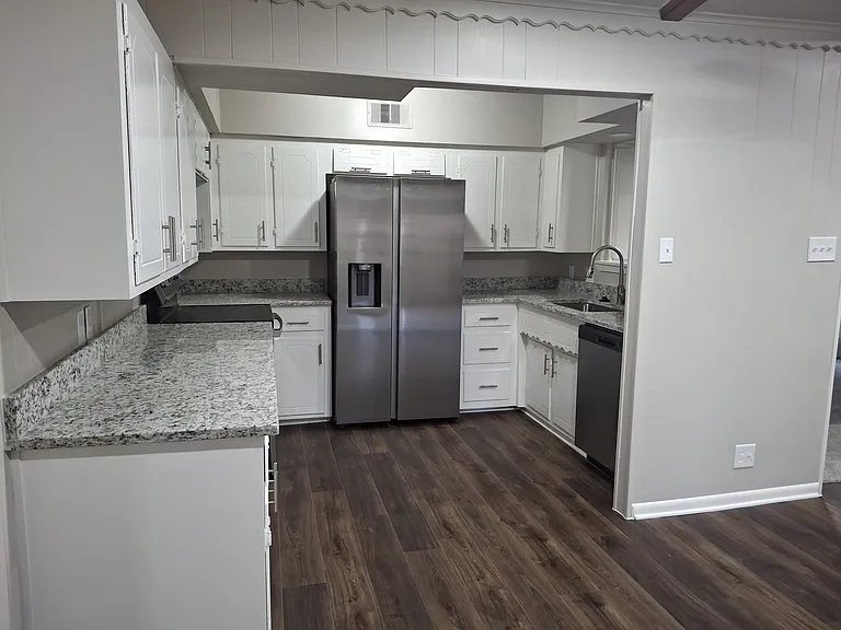 Reconfigured kitchen with new stainless steel appliances. Opens into dining/breakfast room.