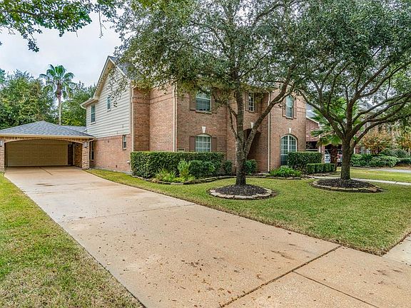 Long driveway leads to a 2 car garage with lots of storage and carport.