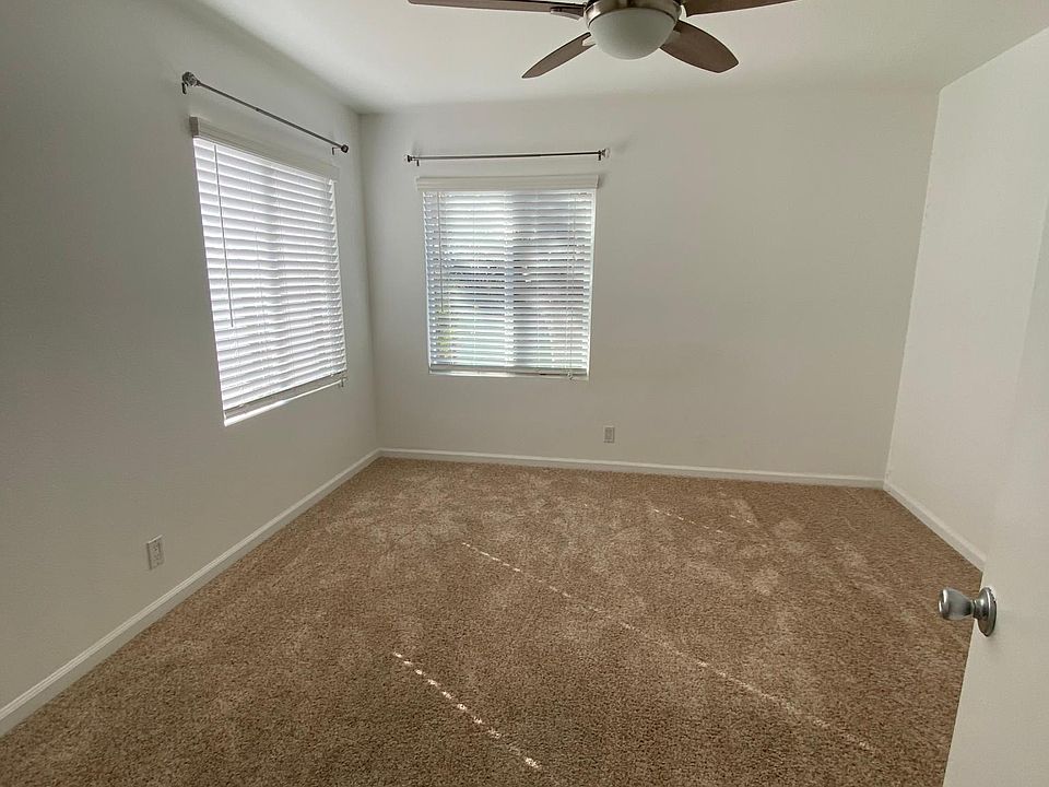 Carpeted Bedroom with ceiling fan and walk-in closet