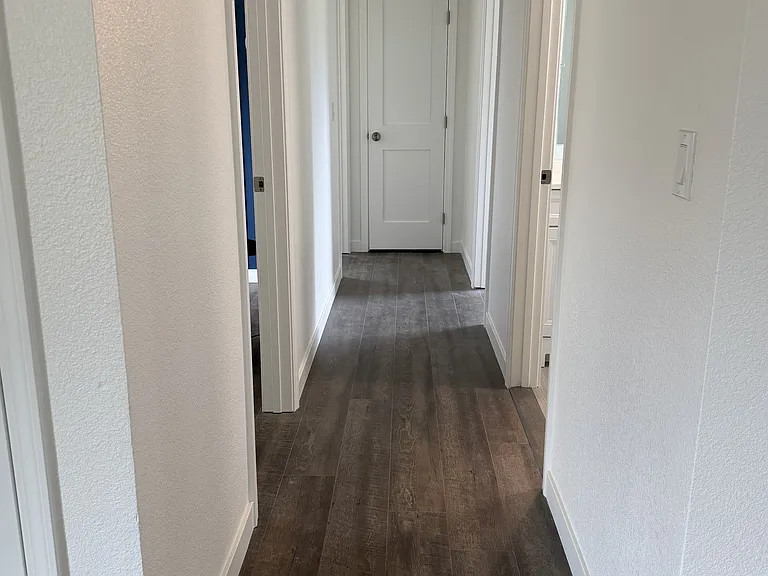 Hallway to all bedrooms. First door on the left is bedroom one, second door on the left is bedroom two. First door on the right is the bathroom and washer/dryer, second door on the right is bedroom three."