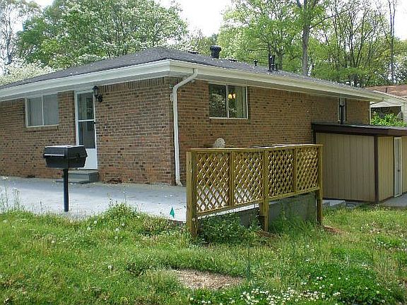 Back of Home with Grill and Entry to Crawl Space