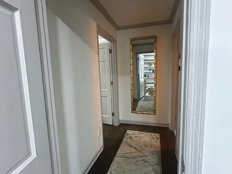 Bright, inviting hallway guiding you to a stylish bathroom retreat.