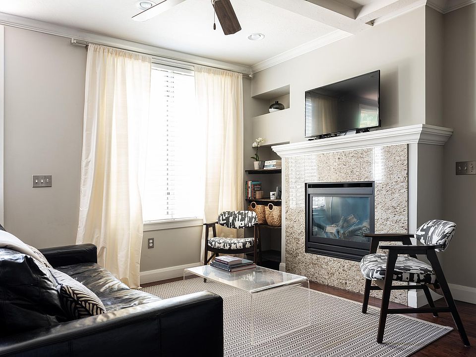 Bright living room open to kitchen and dining spaces for open concept living. Cozy gas fireplace is focal point of the room.