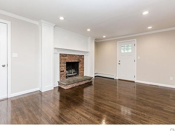 Den with remodeled decorative wood-burning brick fireplace and recessed lighting! Left door opens to