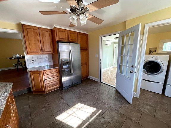 Kitchen fridge wall with pantry, laundry area, glimpse of sunroom