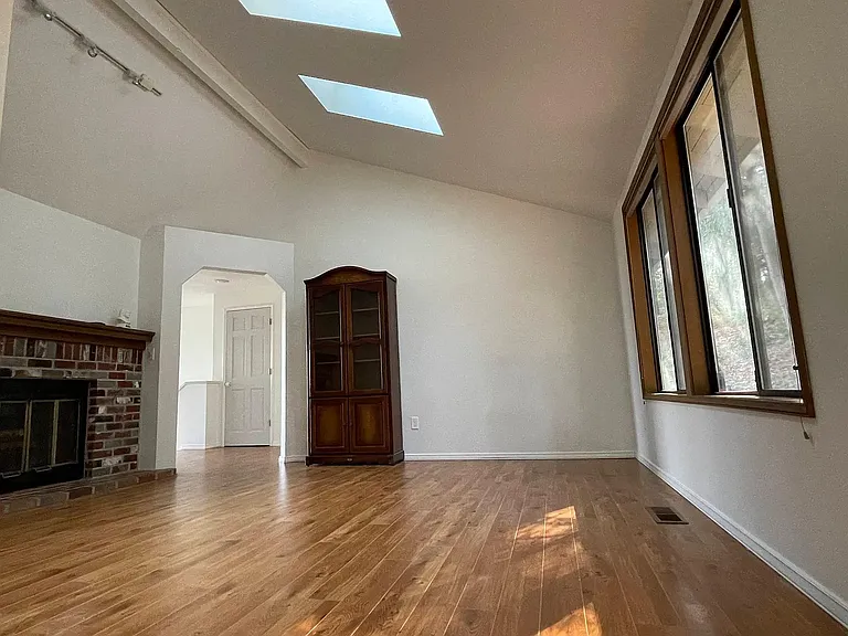 Hardwood flooring and a vaulted ceiling in the living room.
