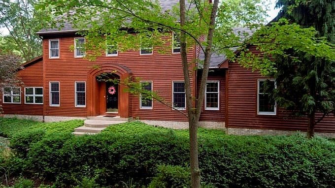 Lovely custom built home with (left) vaulted lodge-like addition and (right) 3-car attached garage.  The fabulous landscaping is