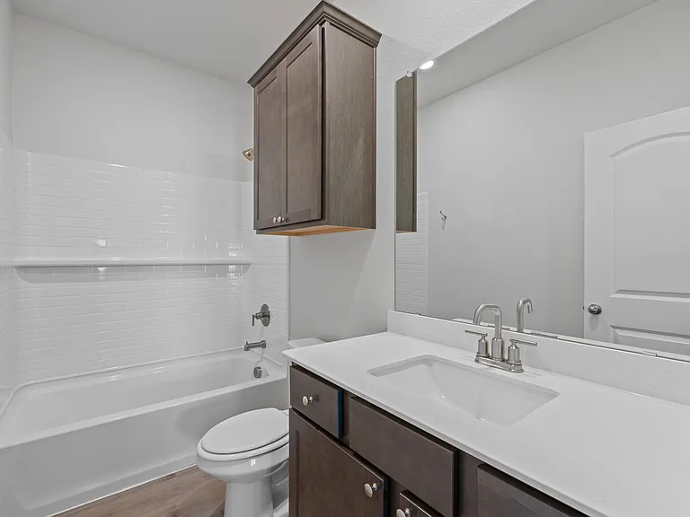 The secondary bathroom has a large vanity space and shower-tub combo.