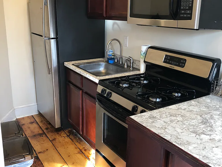 Kitchen w/ gas range, microwave, and stainless steel fridge