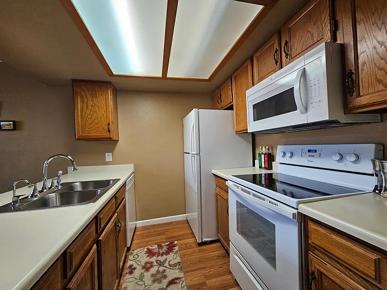 Kitchen has all white newer appliances.