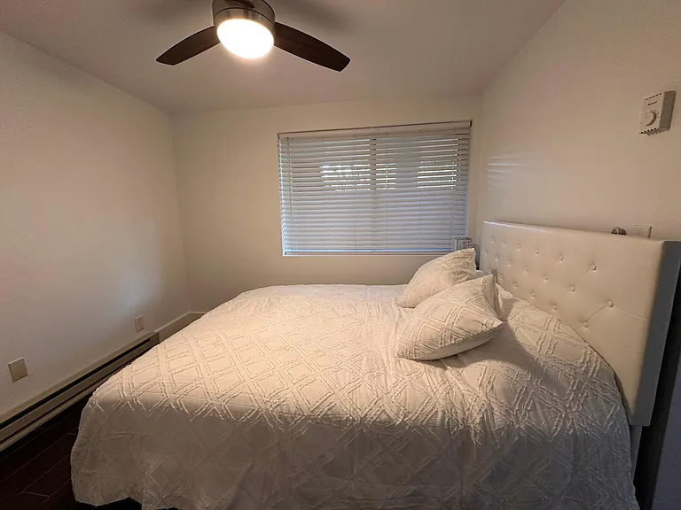 Bedroom view with Fan and baseboard heater.