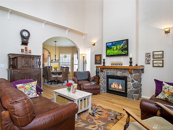Lovely covered front porch welcomes you to the living room space, which is adorned with a gorgeous real rock fireplace- natural gas.