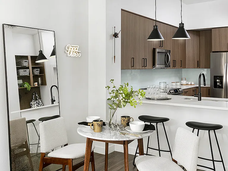 Apartment Kitchen with Stainless Steel Appliances, quartz counters, and wood floors.