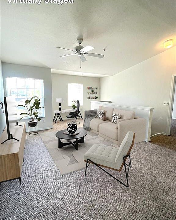 Living room view with home office set-up. Virtually staged photo.