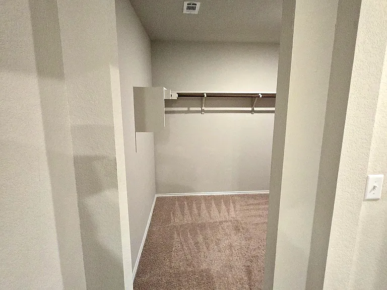Spacious walk-in closet in primary bedroom and bathroom.