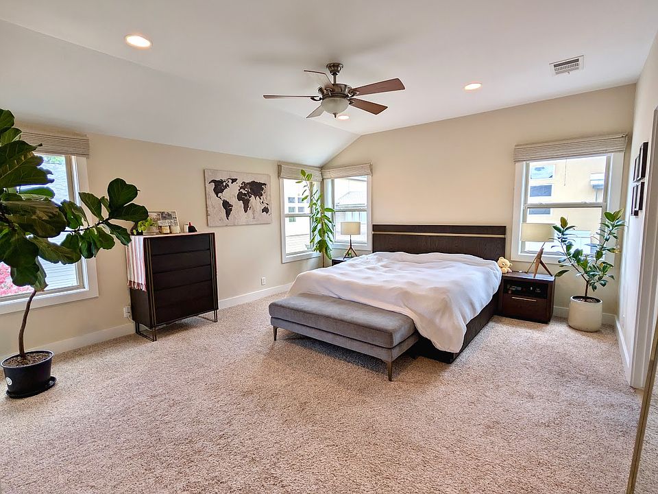 Spacious sun-drenched master suite with double aspect windows and leafy views