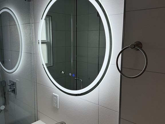 Mirror with integrated lighting and a digital clock.