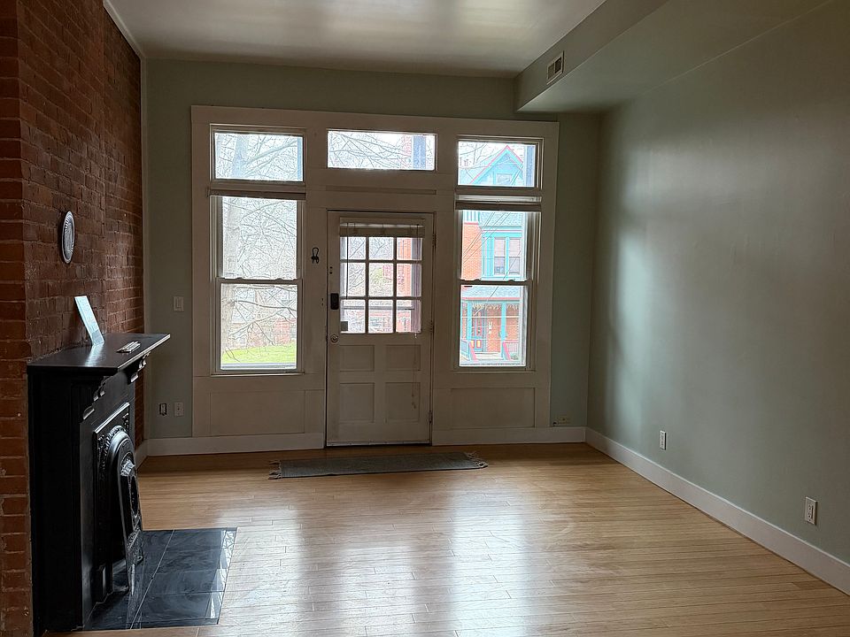 Living room w/ fireplace and exposed brick wall