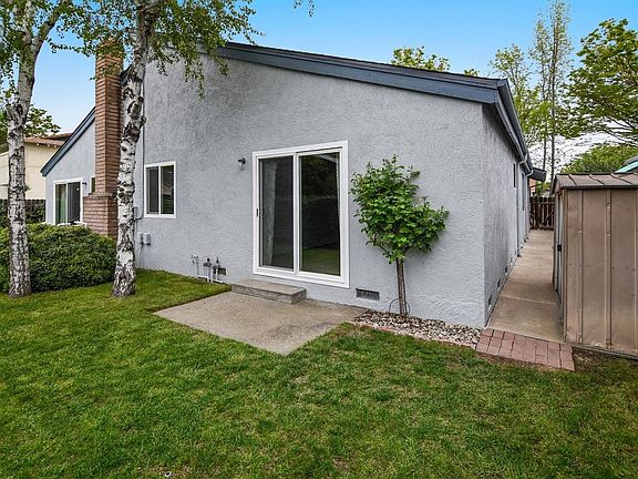The backyard has lawn for outdoor fun.  The sliding door leads tot he owners' suite.  The sellers are willing to remove the shed if buyers prefer...