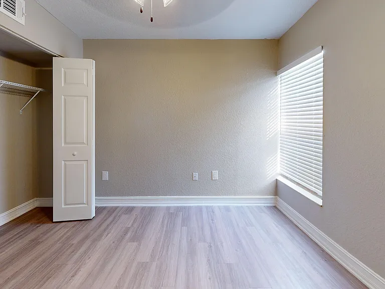 Experience comfort in this bright and airy bedroom, featuring elegant wood flooring and ample closet space.