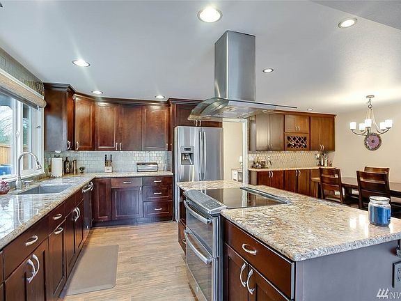 Beautiful remodeled kitchen offers slab granite counters, custom full tile back splash and over sized island.