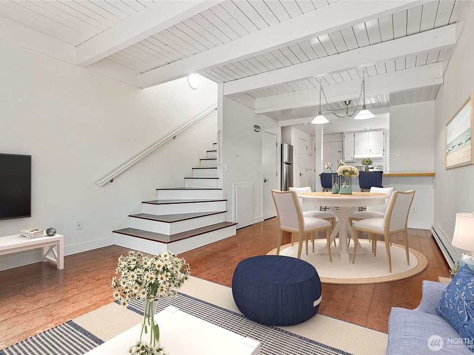 Tall ceilings with white wood plank details give it that beachy vibe. Nice open living room space. Virtually staged.>