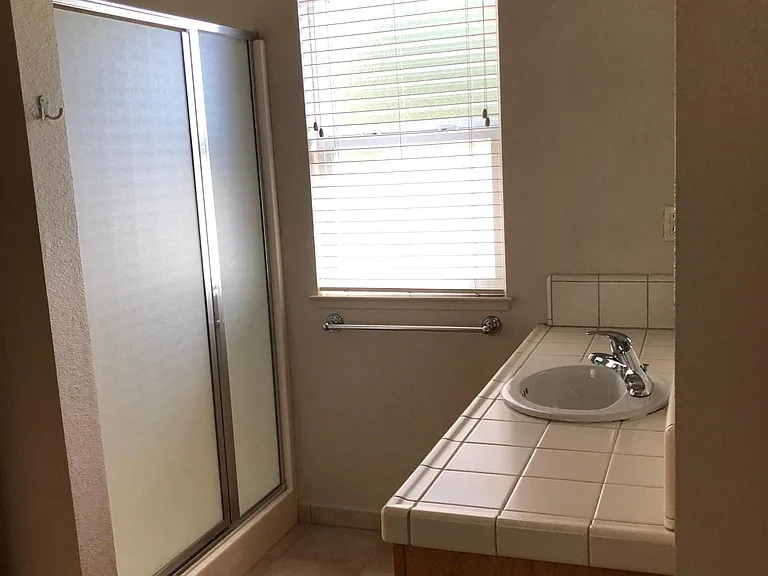 Primary bathroom includes a shower and two adjoining closets with mirror doors.