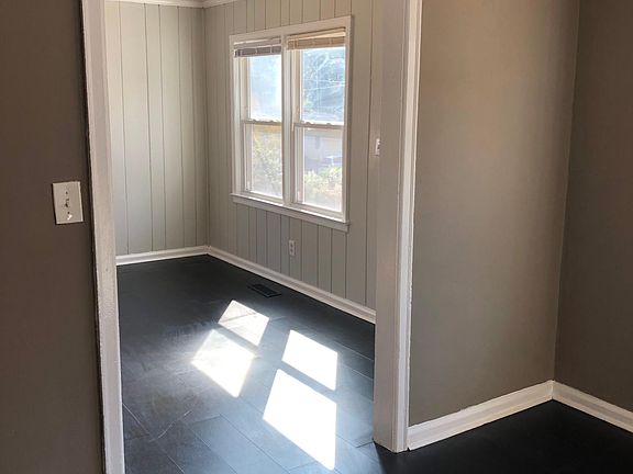 View of dining room overlooking living room. Newly restored floors and fresh paint.