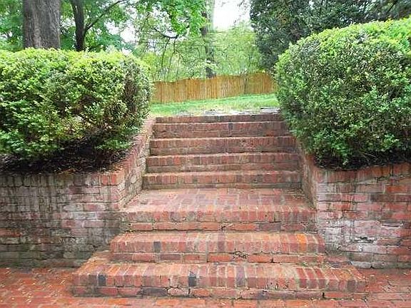 Stairs from brick patio to the fully fenced private backyard