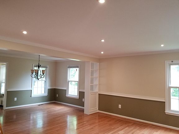 Spacious living room consists of warm colors and recessed lights.