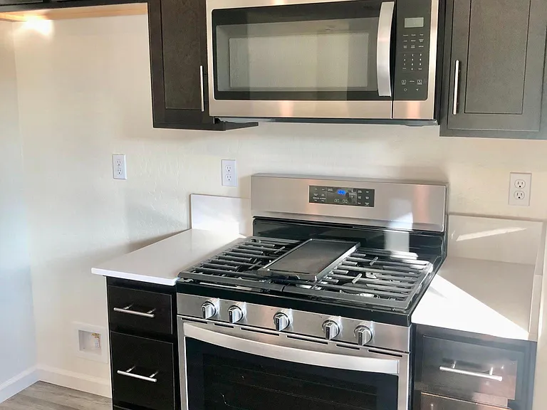 5 burner gas range, stove and microwave. Whirlpool stainless steel appliances.