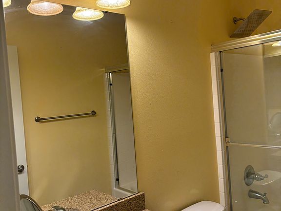 Clean and private full bathroom with bathtub, shower, sink, large mirror, and ample storage. Shared only between top-floor tenants. Bright, fresh, and easy to maintain.