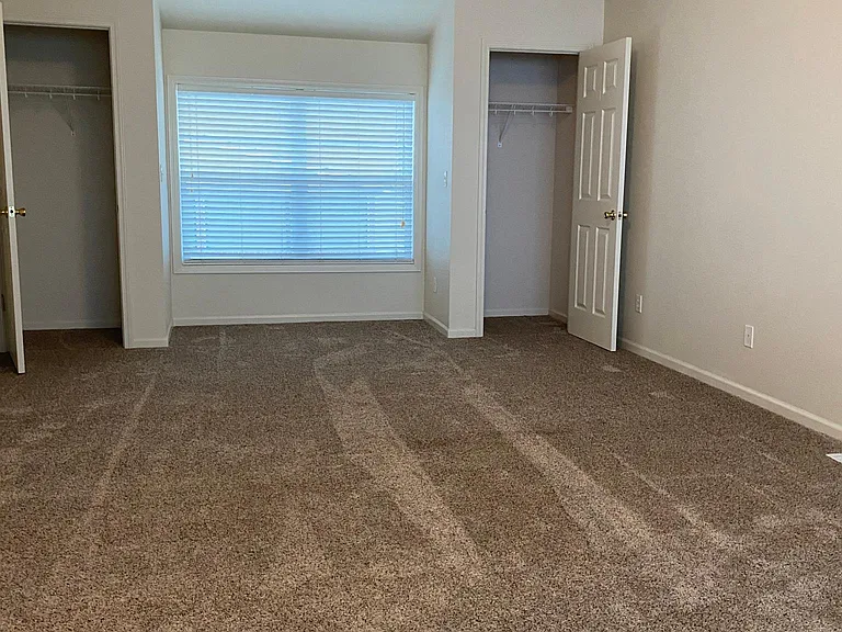 Main Bedroom w/ Closets on both sides of the window that looks out to the street