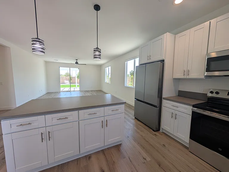 Kitchen and island overlooking open concept dining/living room. New appliances, good cabinet storage
