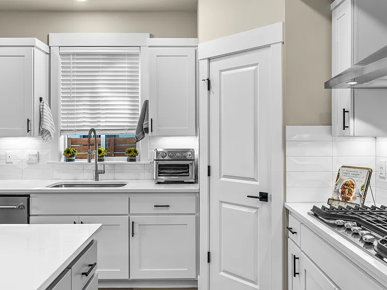 Large kitchen w/quartz countertops, island, walk-in pantry, stainless Kitchen Aid Appliances including gas cooktop, convection oven, microwave, dishwasher and refrigerator.