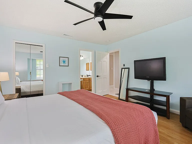 Bedroom 1 - a king bed, smart tv and a chair for additional seating with a large window allowing lots of light into the room.